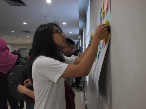 Salah satu peserta seminar "Smart Student: The Best of Me" sedang menempelkan kertas yang berisikan motivasinya di Student Lounge Universitas Multimedia Nusantara, Rabu (27/4)