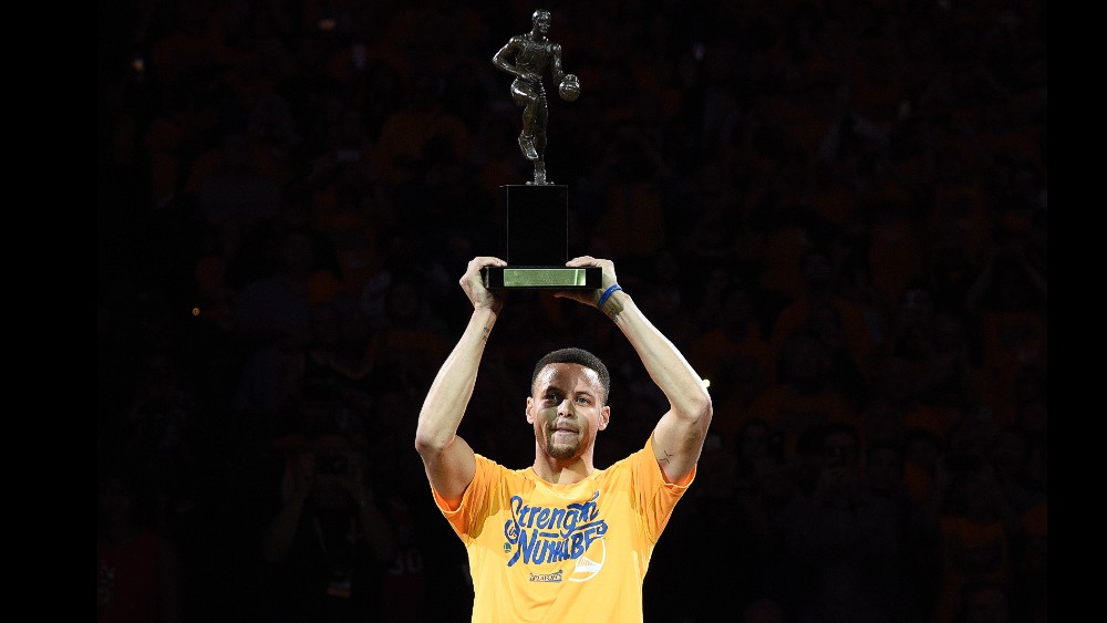 Stephen Curry menerima trofi MVP-nya sebelum laga melawan Blazers dimulai.