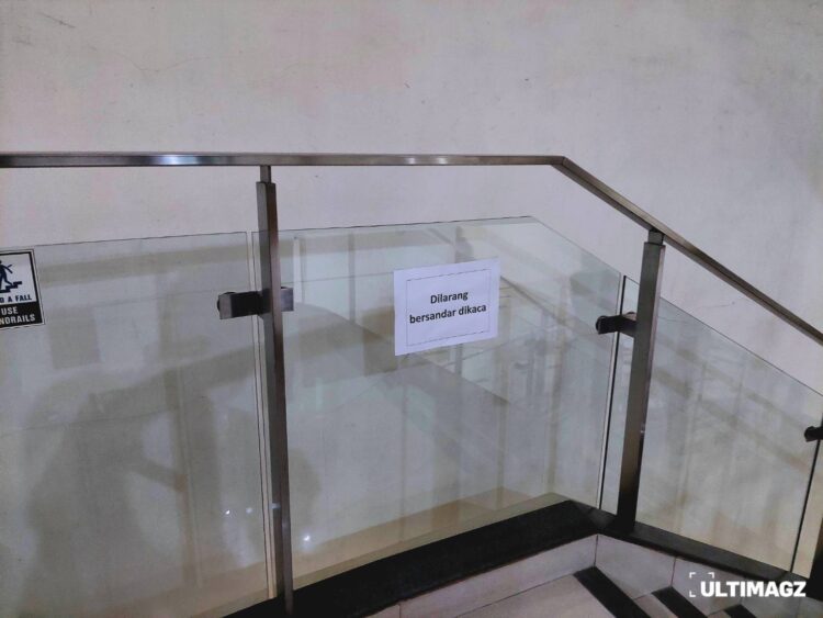 Kertas peringatan untuk tidak bersandar di pagar kaca lantai 5 Gedung C Universitas Multimedia Nusantara, Kamis (09/03/23) (ULTIMAGZ/Rafael Amory J)