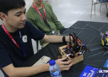 Dua orang mahasiswa selaku kreator dari robot interaktif yang dipamerkan pada pameran BYTE di Lobby D PK Ojong, Universitas Multimedia Nusantara pada Senin (3/11/25). (ULTIMAGZ/Tiffany Michiko P)