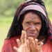 Foto seorang perempuan Papua melakukan tradisi Iki Palek (nationalgeographic.grid.id)