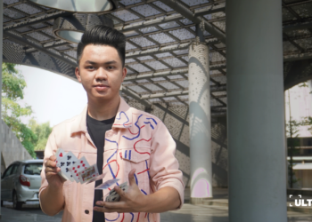 Aaron Nathanael mahasiswa Komunikasi Strategis 2022 UMN sedang memainkan trik kartu. (ULTIMAGZ/Bryant Alexander)