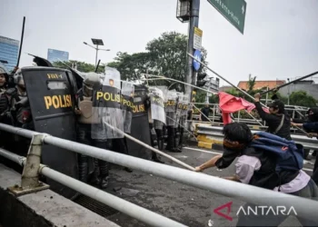 Personel polisi menghalau pengunjuk rasa di Jalan Letjend S. Parman, depan Gedung DPR, Jakarta, pada Senin (25/08/25). (antaranews.com/Bayu Pratama)