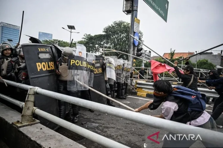 Personel polisi menghalau pengunjuk rasa di Jalan Letjend S. Parman, depan Gedung DPR, Jakarta, pada Senin (25/08/25). (antaranews.com/Bayu Pratama)