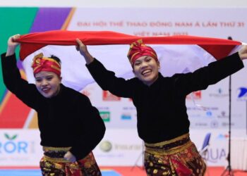 Pasangan pesilat ganda putri Indonesia, Riska (kiri) dan Ririn (kanan) merayakan kemenangan pada Rabu (11/05/22) di ajang SEA Games 2021. (Foto: NOC Indonesia/ Naif Al’as)