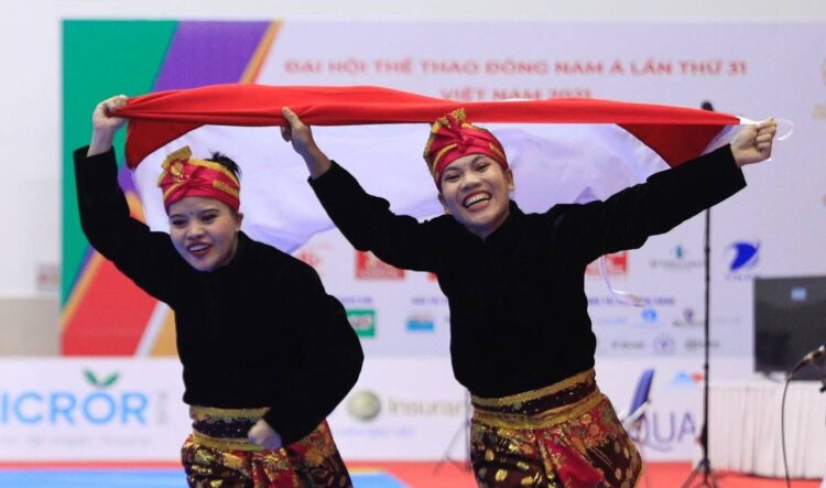 Pasangan pesilat ganda putri Indonesia, Riska (kiri) dan Ririn (kanan) merayakan kemenangan pada Rabu (11/05/22) di ajang SEA Games 2021. (Foto: NOC Indonesia/ Naif Al’as)