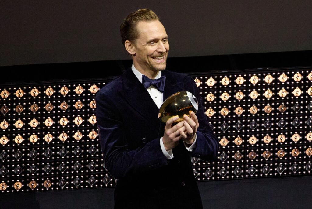 Tom Hiddleston memegang piala penghargaannya dalam Zurich Film Festival pada Kamis (24/09/26). (Instagram/@zurichfilmfestival)