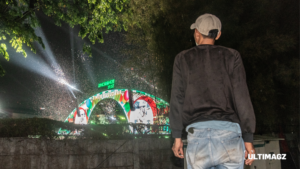 Seorang pekerja menyaksikan suasana Synchronised Fest 2026 dari luar area acara di Jakarta International Expo (JIExpo), Kemayoran, Jakarta Pusat, DKI Jakarta, Minggu (18/10/2026). (ULTIMAGZ/Gabri Perboire)