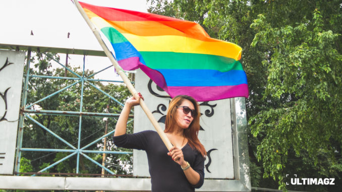 Transpuan memegang bendera LGBT