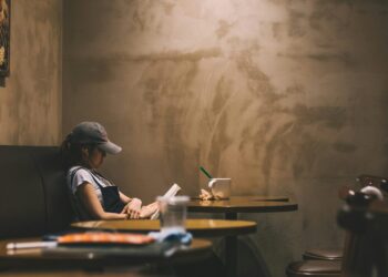 Ilustrasi perempuan yang sedang membaca buku di kafe. (Unsplash/@Bundo Kim)