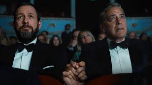 Sepotong adegan dari film Jay Kelly, menunjukkan potret dua lelaki berpegangan tangan dengan emosional.