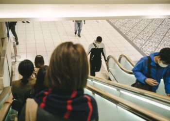 Beberapa orang yang sedang berdiri dan berjalan di atas eskalator. (freepik.com)